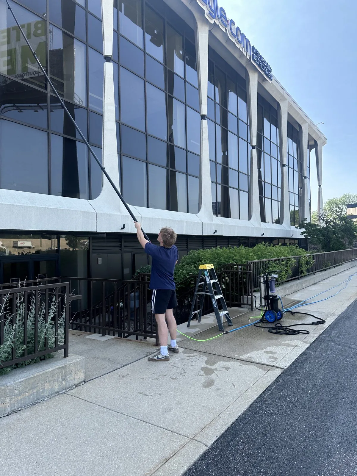 ClearDay technician cleaning commercial storefront windows with a water-fed pole
